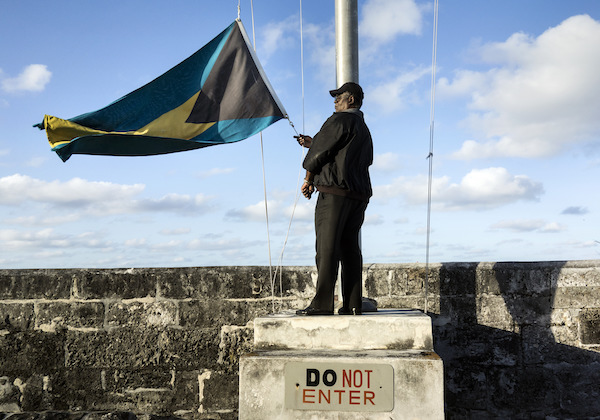 **FILE** A security guard lowers the Bahamian flag at Fort Charlotte on December 19, 2013 in Nassau, Bahamas. The fort is one of several that remain from the British colonial era. (BRENDAN SMIALOWSKI/AFP/Getty Images)