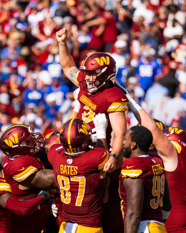 Commanders team holding up kicker Austin Seibert after his victory kick increases the final score to 21-18. (Abdullah Konte/The Washington Informer)