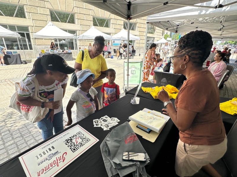 Angie Johnson promotes the annual Washington Informer Spelling Bee to future participants at the Capital Book Fest on Saturday, June 15 at the Woodrow Wilson Plaza in D.C. (D.R. Barnes/The Washington Informer)