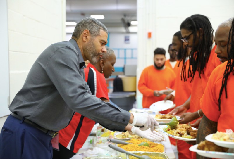 Industrial Bank President B. Doyle Mitchell Jr. helps serve food to inmates. (Tyler Palmer/Department of Corrections)