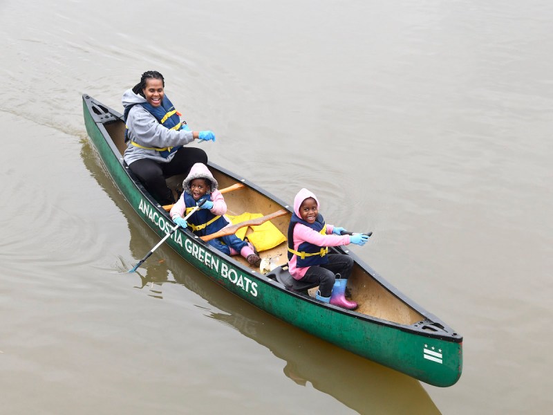 As part of a river cleanup guided by Living Classrooms, Sheree Pendleton paddles along the Potomac with children Olivia Grace and Hannah Bell during a family day at Kingman and Heritage Islands October 2023. (Robert R. Roberts/The Washington Informer)