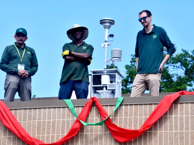 Members of the air quality monitoring team at the D.C. Department of Energy and Environment stand next to the new Ward 8 air quality monitor on the roof of Bald Eagle Recreation Center during the ribbon cutting May 7. (Robert R. Roberts/The Washington Informer)