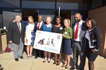 Prince George's County Executive Rushern Baker (3rd from left), Carol Thompson Cole (4th from left), president and CEO of Venture Philanthropy Partners, and Suitland High School Principal Nate Newman (2nd from right) stand with other partners in front of Suitland High School's Annabelle Ferguson Auditorium in Forestville, Md., on Nov. 4 to announce Venture's partnership with county schools to raise $15 million for a college-prep program. Photo by Roy Lewis