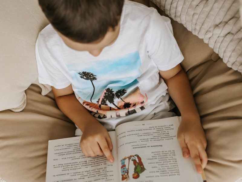 a child reading a book in a hammock