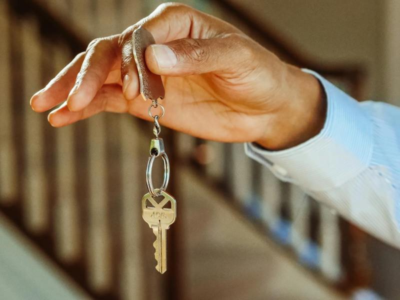 person holding a silver keychain with a key